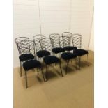 A set of eight wrought iron dining chairs with blue velvet seat pads on hair pin legs
