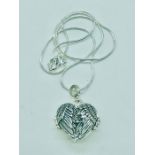 A silver heart shaped locket in the form of wings of peace on a silver chain