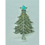 A silver and marcasite Christmas Tree brooch set with an opal star finial.