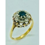 An 18ct yellow gold ring, centre claw set 5mm round sapphire with eight illusion set diamonds.