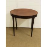 An elegant small oval side table on tapered legs