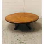 An oval coffee table of Victorian origins with a marquetry inlaid top on a modified base