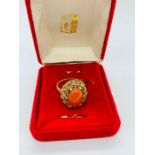 A 9ct yellow gold ring with a coral centre stone