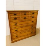A pine five over three chest of drawers with brass drop down handles (H136cm W133cm D51cm)