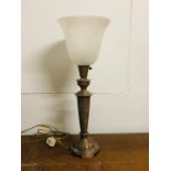 A brass coloured metal table lamp with glass shade