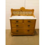 A double pine washstand with marble top, tiled splash back on bun feet