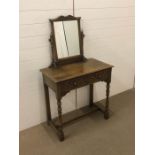 A small carved oak dressing table with two drawers and tilt mirror circa 1920