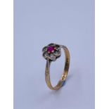A 9ct gold ring with ruby and diamonds in a daisy style setting.
