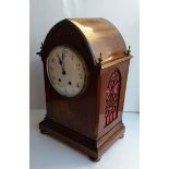 An Edwardian mahogany-cased domed mantel clock with brass finials and inlay decoration, Arabic