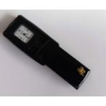 A Van Cleef & Arpels foldaway quartz miniature travel clock with canted rectangular silvered dial,