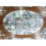 An Oriental convex hardwood oval wall hanging with allegorical scenes with mother-of-pearl