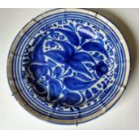 Two 18th century blue and white delft tin plate circular chargers with floral and foliate