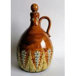 An Edwardian Royal Doulton Lambeth whisky jug with stopper in mottled tan-ground with floral and