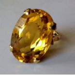 An oval citrine stone dress ring on 9ct yellow gold: the mixed-cut citrine 22.6mm x 15.5mm x 10.6mm,