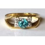 An 18ct yellow gold blue topaz and diamond dress ring, the round topaz 4.5mm, 0.36 metric carat,