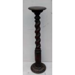 An Arts & Crafts mahogany jardiniere or candle stand with rope-twist column and carved decoration to