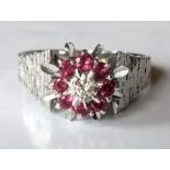 A diamond and ruby cluster ring on an 18ct white gold setting: the round brilliant-cut diamond 2.