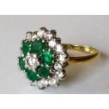 A diamond and emerald cluster ring: the central brilliant-cut diamond 4.2mm x 2.6mm, approx 0.28