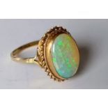 An cabochon opal ring with rope-twist border on a 9ct gold setting, size Q, hallmarked, 3.11g