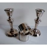 Two silver napkin rings, mixed dated, 59g and a pair of smaller silver candlesticks, weighted,