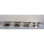 A matching set of four crested George IV Irish silver open salts with later blue glass liners of