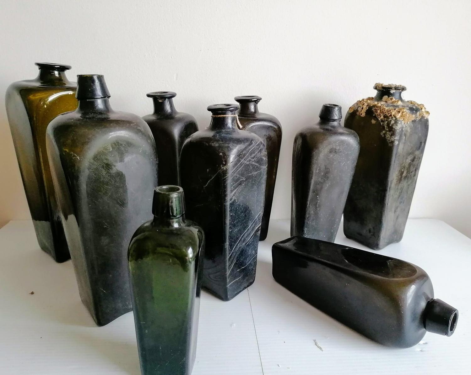 Nine 18th and 19th century Dutch green glass gin bottles, shortest 18.5 cm, tallest 28 cm, one