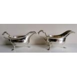 A pair of George II silver sauce boats with leaf-capped scroll handles, gadroon rims on scallop