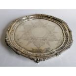 An Edwardian silver salver with embossed and etched decoration on three feet by Walker & Hall,