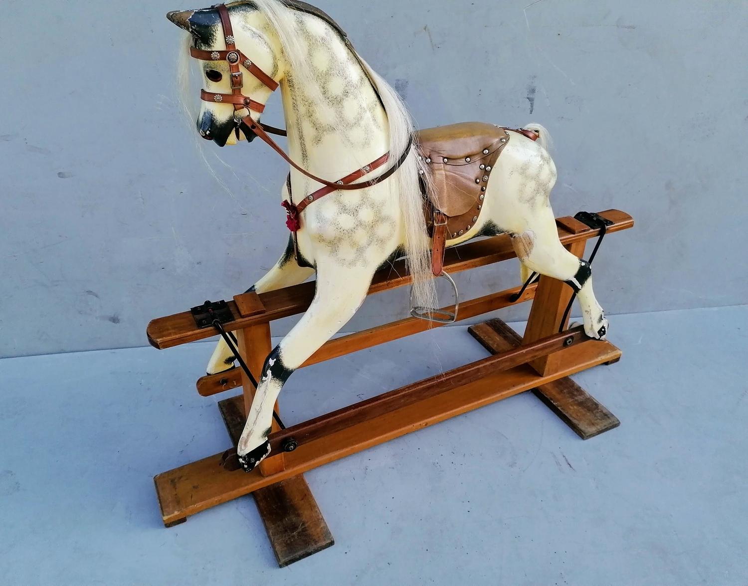 A child's wooden rocking horse painted in dappled grey with horse hair mane, tail, glass eyes,