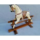 A child's wooden rocking horse painted in dappled grey with horse hair mane, tail, glass eyes,