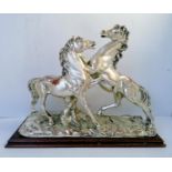 After A. SANTINI a silvered group of metal stallions on a wooden base, signed, stamped ARGENT 925,