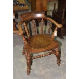 A 19th Century elm and beech wood smokers bow elbow chair With bobbin turned spindles above a shaped