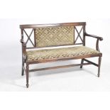 An Edwardian mahogany sofa Having a padded and lattice work back above a padded seat enclosed by out