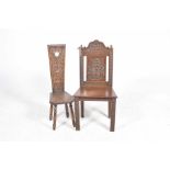 A late 19th Century carved oak hall chair Having acorn finials above a central panel carved with a