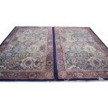 A pair of Tabriz style carpets Each with cobalt blue and pale pink ground, the central reserve