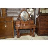 A Victorian mahogany duchess dressing table Having a quatrefoil mirror supported on scrolling leaf