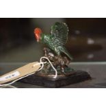 A cold painted brass figure of a parrot The parrot modeled on wooden branch raised on wooden