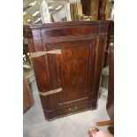 A George III oak and mahogany crossbanded hanging corner cupboard Having a moulded cornice above a