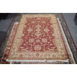 A Ziegler patterned rug The foliate patterned carpet upon a red ground with tasseled edges, 280cm