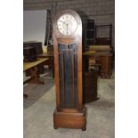 A 1930's Art Deco oak cased long case clock The domed case enclosing a 26cm silvered dial painted