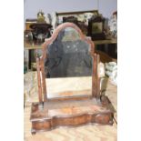 A George II style walnut toilet mirror Having a shaped mirror plate supported on tapering supports