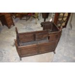 An 18th Century oak cradle Having button shaped finials on turned uprights above panelled sides,