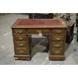 An early 20th Century oak twin pedestal desk Having a rectangular leather inset writing surface