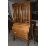 A 1920's oak bureau bookcase Having a caddy top above two glazed doors enclosing two adjustable