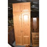 A modern pine two door wardrobe with storage cabinet The storage cabinet with a hinged front above
