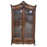 An impressive walnut French style display cabinet, 19th Century The arched pediment with a leafy C