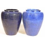 A near pair of glazed earthenware pots/urns Each blue glazed urn with a raised rim above a