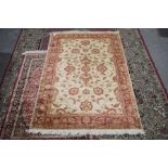 A Ziegler style rug The scrolling foliate design in shades of red and gold upon a beige ground, with