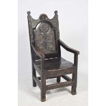 An 18th Century oak Wainscot chair The shaped panelled back centred with carved stylized flower
