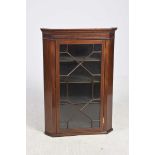 A 19th Century glazed mahogany hanging corner cupboard Having a moulded cornice above a frieze